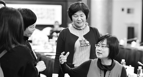 3月11日，人大广东代表团在驻地举行分组会议。全国人大代表龙芳（右一）、李淑明（右二）与同团代表在讨论“一带一路”战略对广东企业“走出去”产生的影响。本报记者 李景录摄