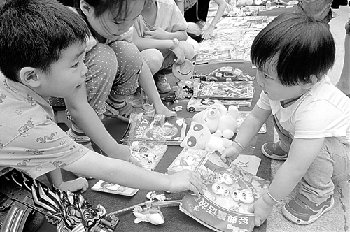 在社区开展的“邻里淘淘乐”活动中，小朋友们在挑选书籍。 崔晓琳摄